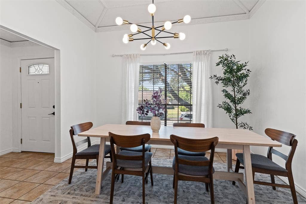 841 Villa Ridge Drive, Garland, TX 75043 Vaulted ceiling with decorative beams, modern sputnik chandelier, large window with blinds and sheer curtains, paneled entry door with decorative glass insert, and tile flooring