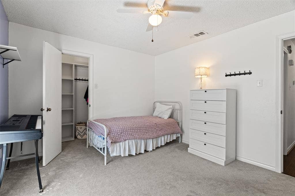 841 Villa Ridge Drive, Garland, TX 75043 Spacious secondary bedroom featuring neutral carpeting, a ceiling fan with integrated lighting, white painted wood framing, and ample natural light