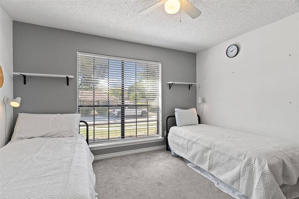 841 Villa Ridge Drive, Garland, TX 75043 Carpeted flooring, window with blinds, ceiling fan with integrated lighting, wall-mounted shelving units, and sconce lighting