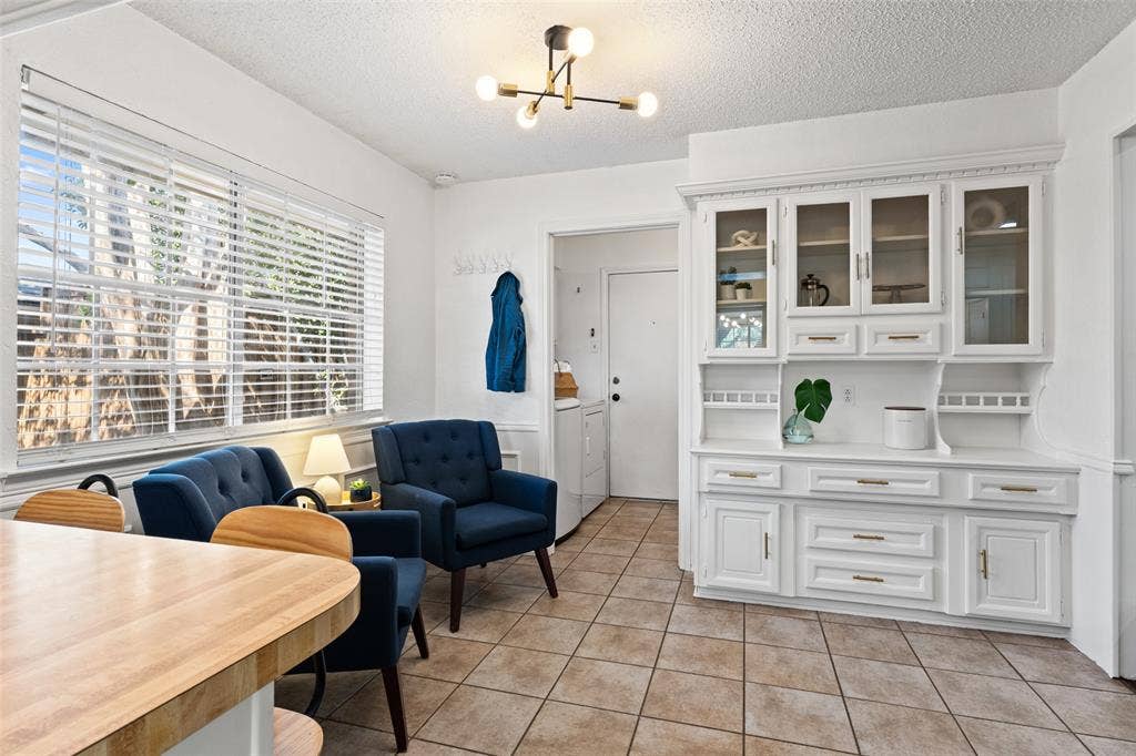 841 Villa Ridge Drive, Garland, TX 75043 Built-in white hutch with glass-front cabinetry, neutral tile flooring, and a large window with blinds