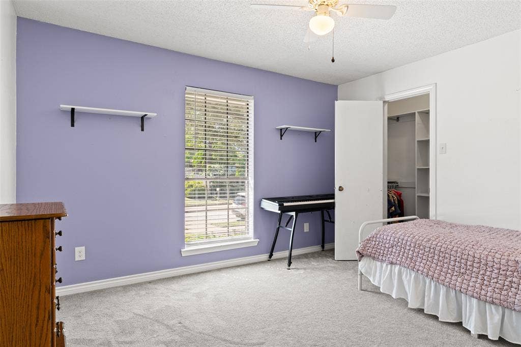 841 Villa Ridge Drive, Garland, TX 75043 Recessed window with blinds, ceiling fan with light fixture, built-in shelving in closet, and neutral-toned carpeting