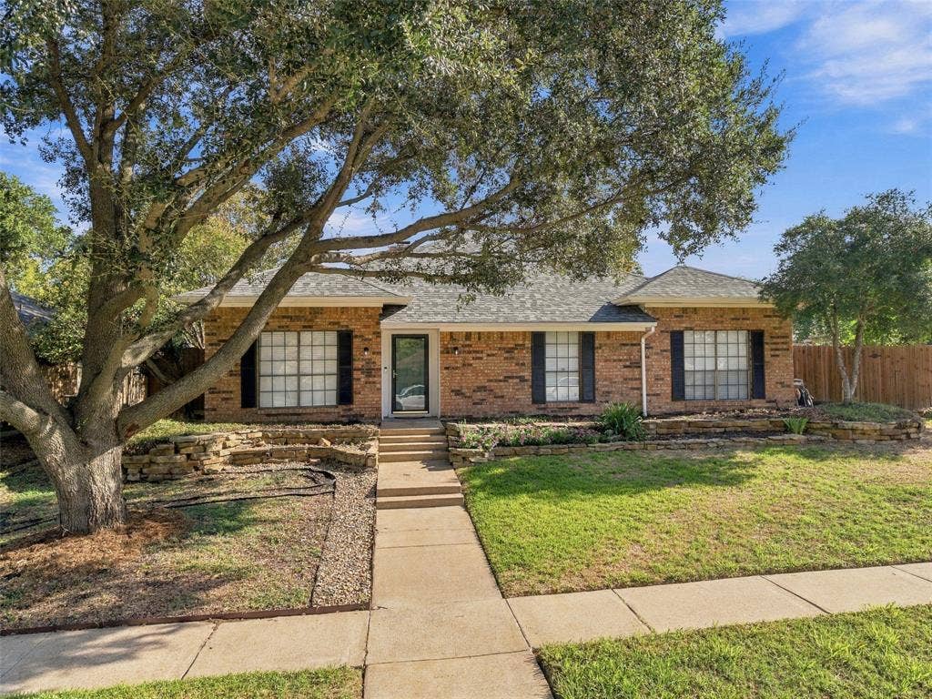 841 Villa Ridge Drive, Garland, TX 75043 Brick exterior with a gabled roofline, mature trees, and a concrete pathway