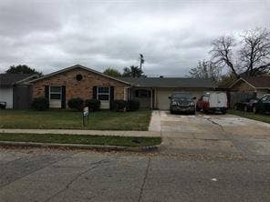 Brick exterior, attached garage, paved driveway, front lawn, mature landscaping