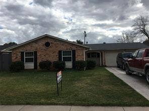 Brick facade with dark shutters, gabled roofline, and attached garage