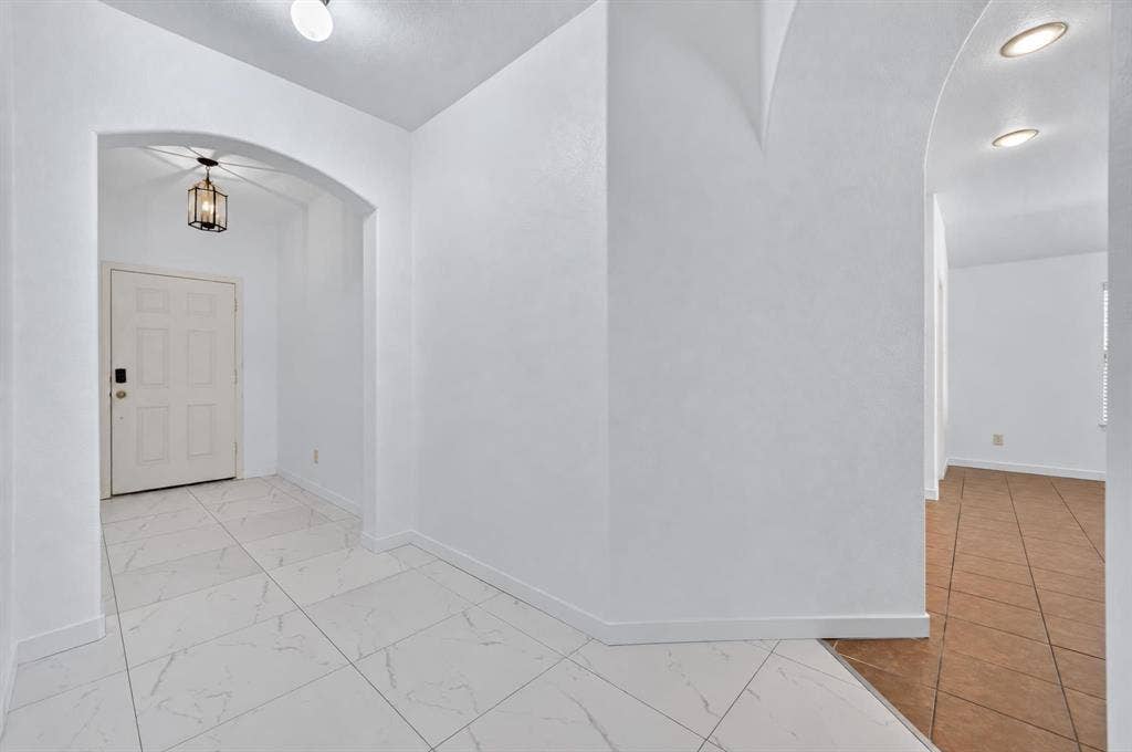1048 Mercury Drive, Lavon, TX 75166 Entryway featuring white square tile flooring, archway, and a dark bronze hanging lantern fixture