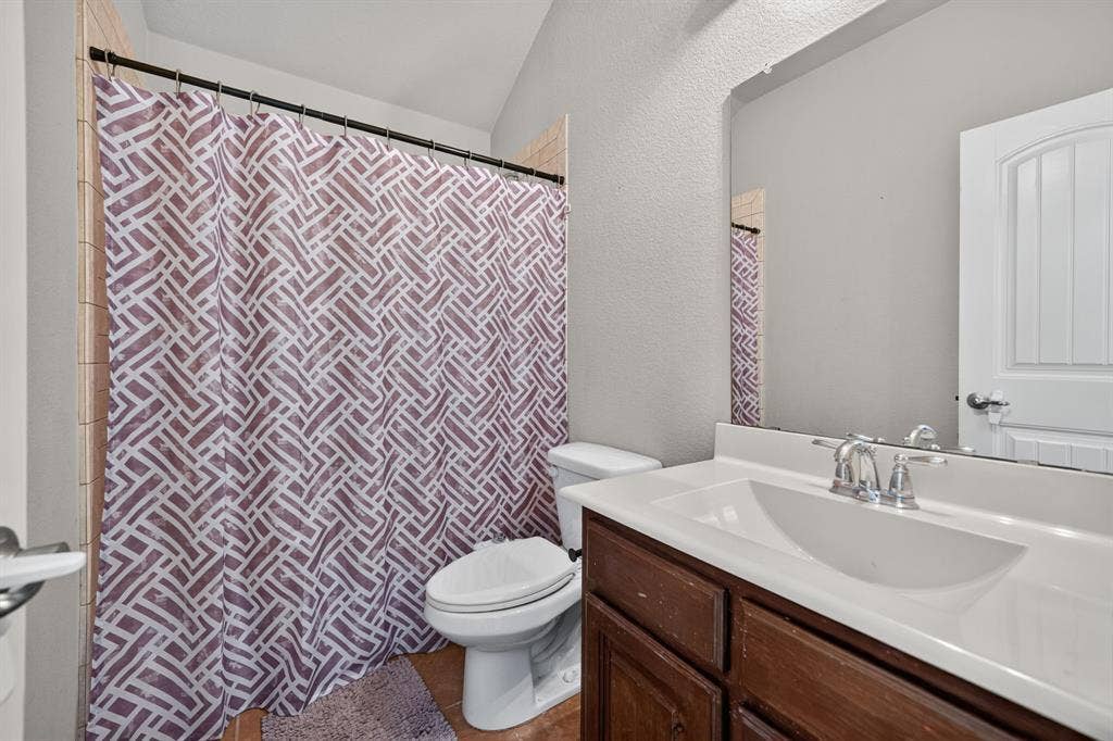 1048 Mercury Drive, Lavon, TX 75166 Bathroom featuring a dark wood-finish vanity, integrated sink, chrome faucet, and a large wall mirror