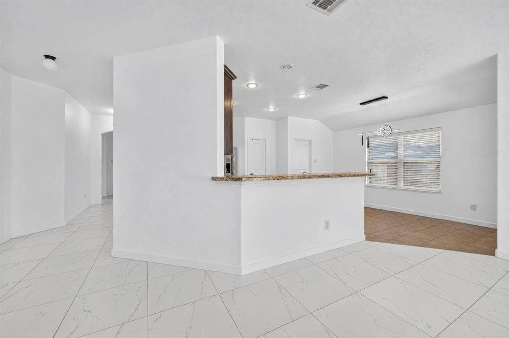 1048 Mercury Drive, Lavon, TX 75166 White tile flooring, breakfast bar with a stone counter, recessed lighting, and a window with blinds