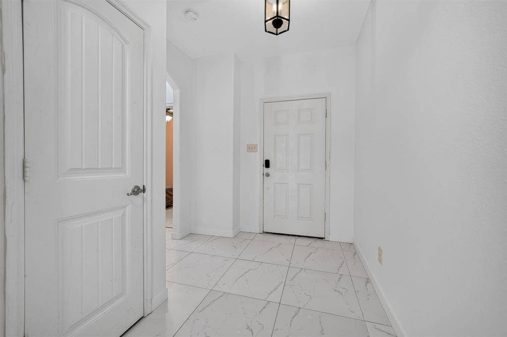 1048 Mercury Drive, Lavon, TX 75166 Spacious entryway with large format floor tile, recessed lighting, and a modern pendant light fixture