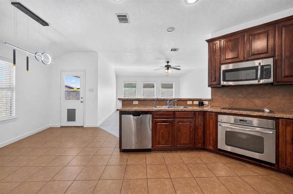 1048 Mercury Drive, Lavon, TX 75166 Kitchen featuring wood-finish cabinetry, stainless steel appliances, and a built-in microwave