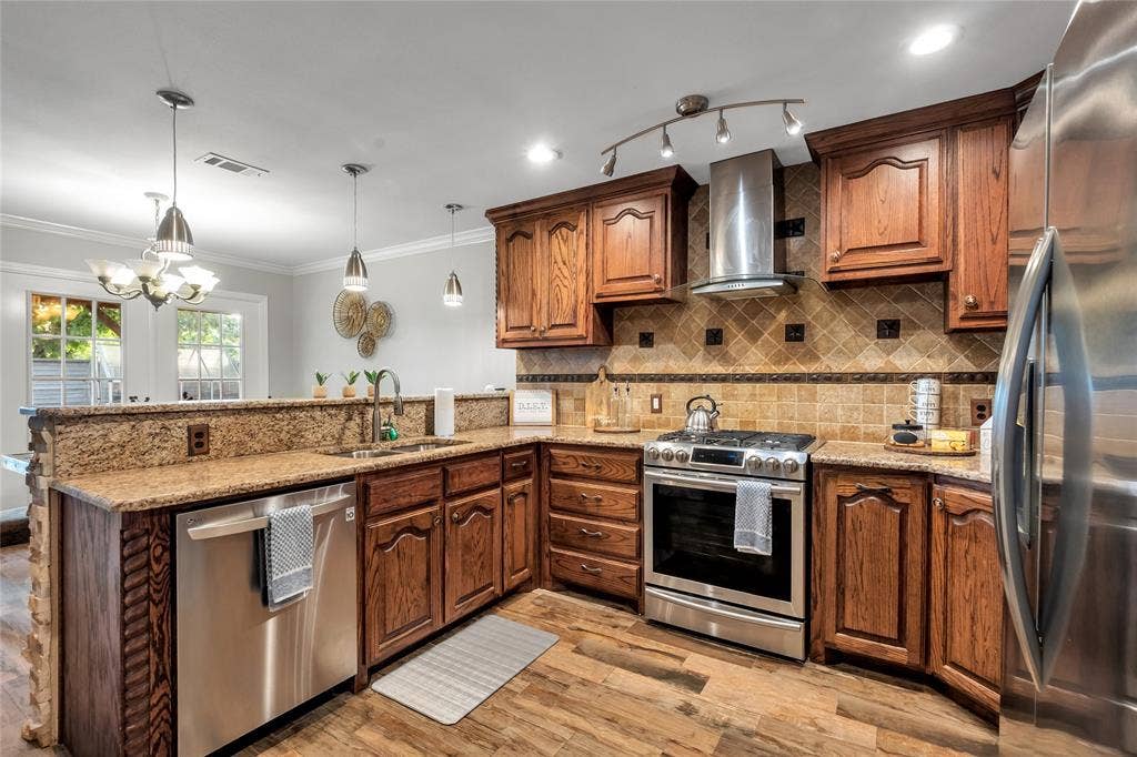 4523 Wescott Drive, Grand Prairie, TX 75052 Wood-finish flooring, granite countertops, stainless steel appliances, wood cabinetry, and a tile backsplash