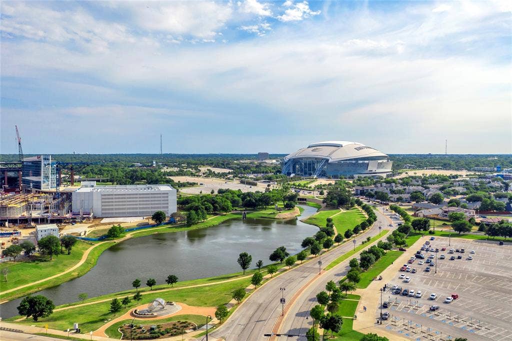4523 Wescott Drive, Grand Prairie, TX 75052 Aerial perspective showcasing premium waterfront positioning with manicured grounds, mature landscaping along the water's edge, and expansive green space