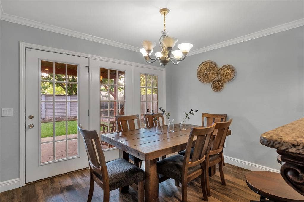 4523 Wescott Drive, Grand Prairie, TX 75052 Wood-finish flooring, crown molding, and a multi-light chandelier illuminate this dining area