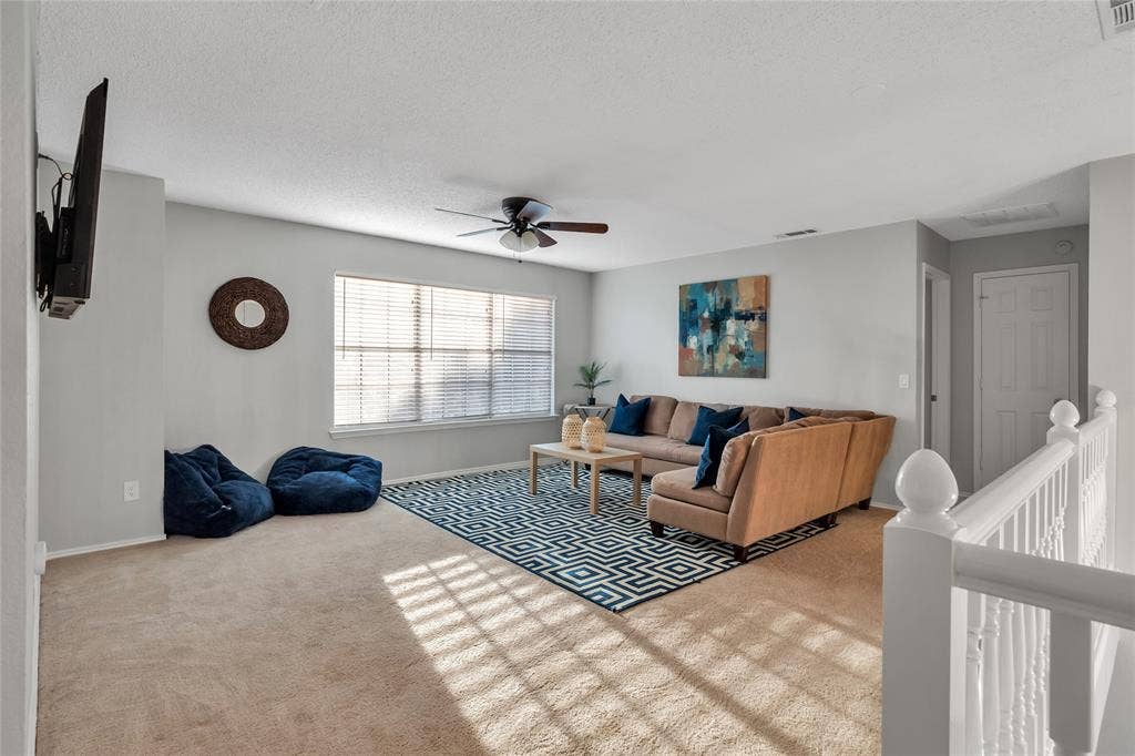 4523 Wescott Drive, Grand Prairie, TX 75052 Spacious room with light-colored carpeting, large windows with blinds, and a ceiling fan