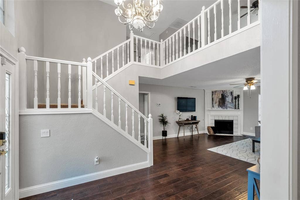 4523 Wescott Drive, Grand Prairie, TX 75052 Two-story entryway with wood-finish flooring, white spindle staircase, and a decorative chandelier