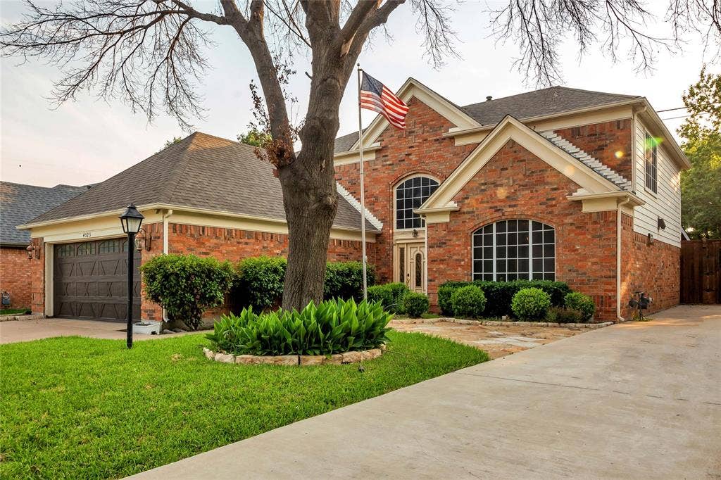 4523 Wescott Drive, Grand Prairie, TX 75052 Brick exterior with arched windows, prominent front entry, attached garage, and concrete driveway