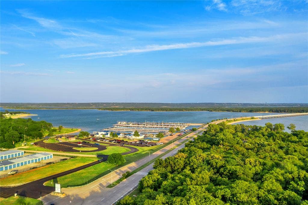 4523 Wescott Drive, Grand Prairie, TX 75052 Expansive waterfront featuring a marina with numerous boat slips, a paved roadway, and extensive natural tree coverage