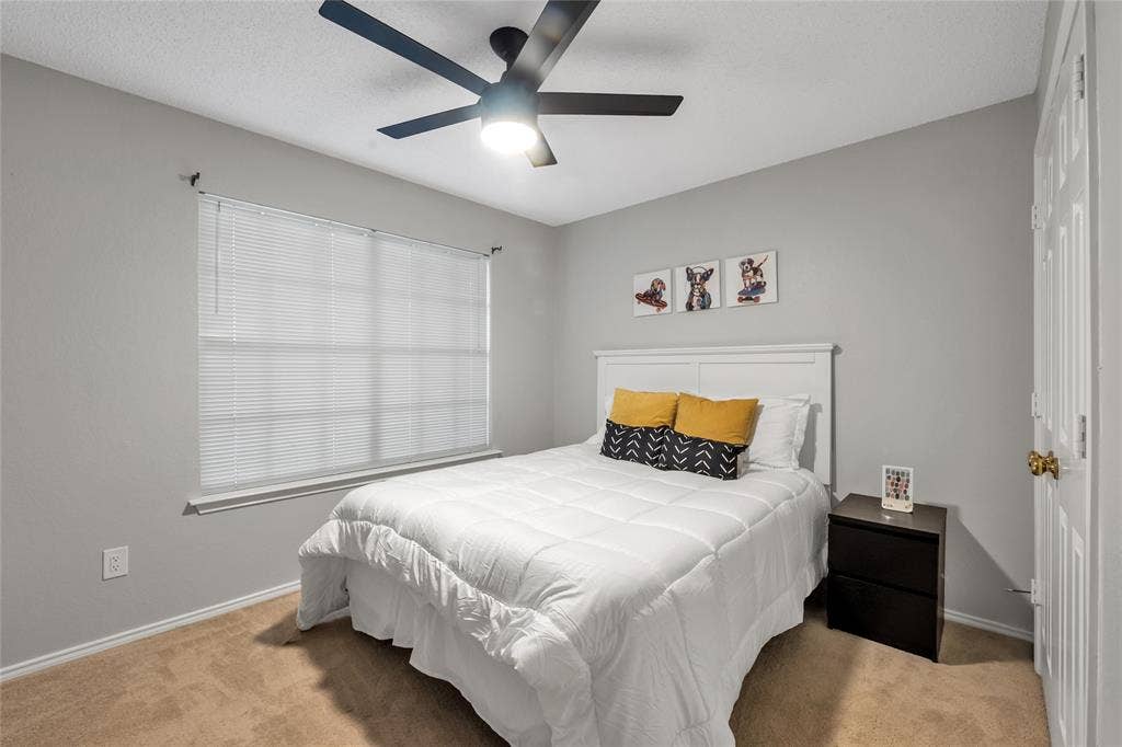 4523 Wescott Drive, Grand Prairie, TX 75052 Neutral wall paint, ceiling fan, window with blinds, carpeted flooring, and a white paneled door