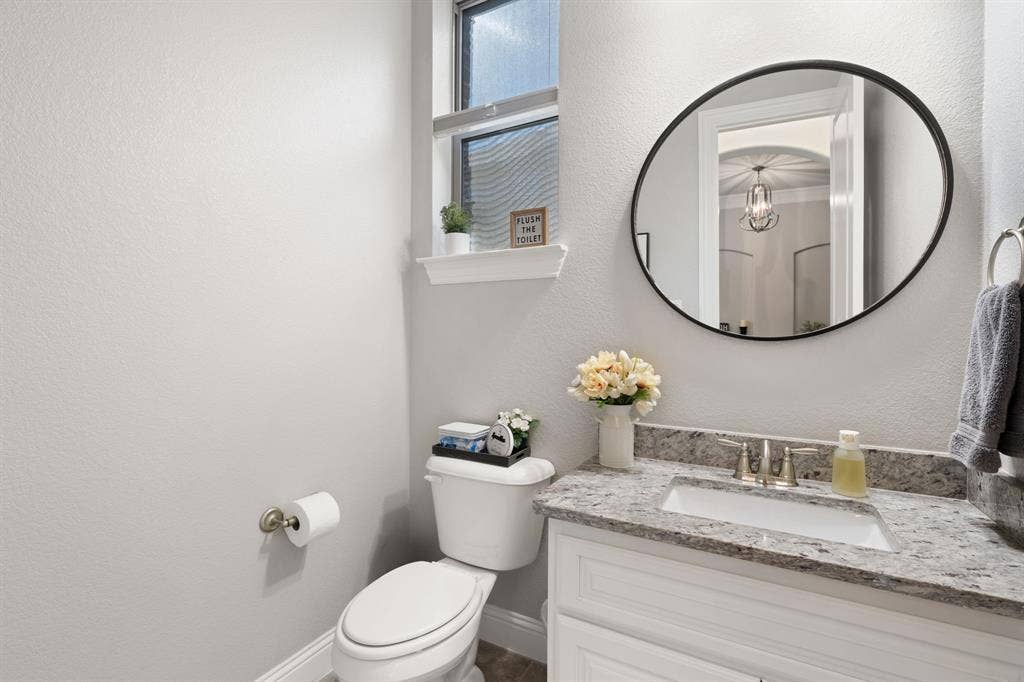 Vanity with a granite-style countertop, undermount sink, and brushed nickel faucet