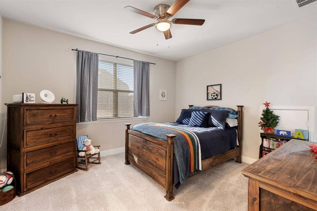 Recessed window with blinds and drapes, ceiling fan with integrated lighting, and neutral wall paint