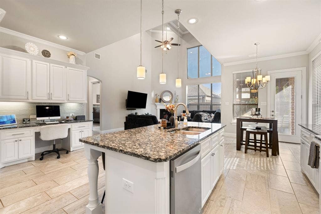 Spacious kitchen featuring a large island with a double sink and stone countertops