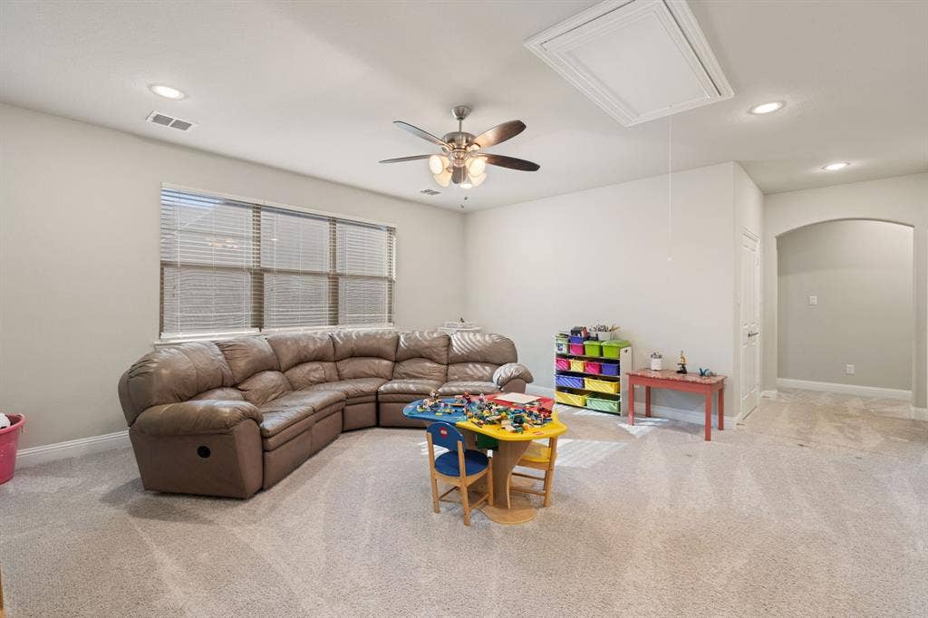 Carpeted room featuring a ceiling fan, recessed lighting, and a window with blinds