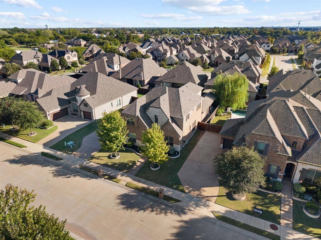 Stone and brick exterior with a multi-gabled roof, integrated two-car garage, and a lush green lawn