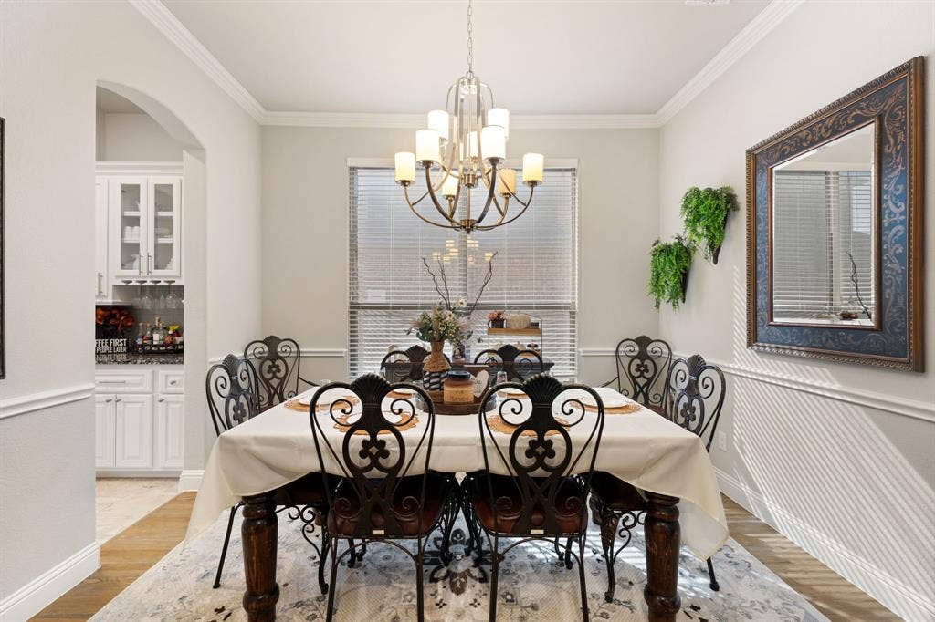 Formal dining space featuring crown molding, chair rail, and wood-finish flooring