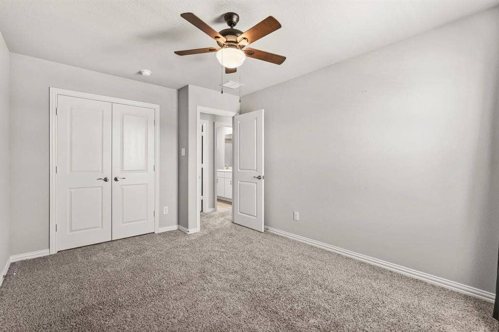 Plush carpet flooring, ceiling fan with integrated lighting, double-door closet, and neutral wall tones