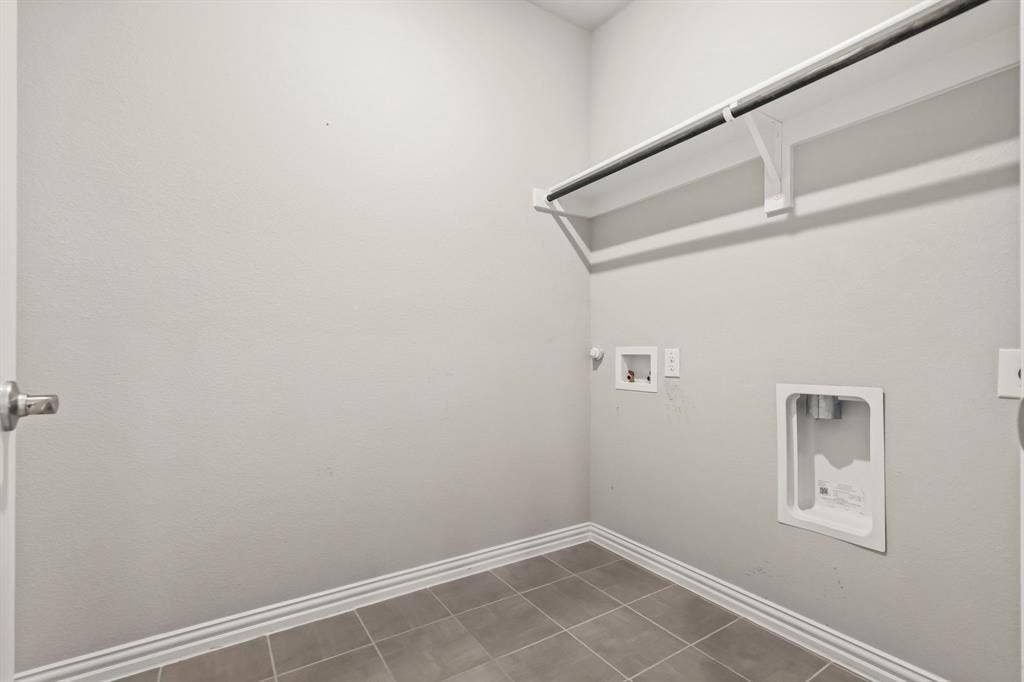 Utility room with tiled flooring and a built-in hanging rod