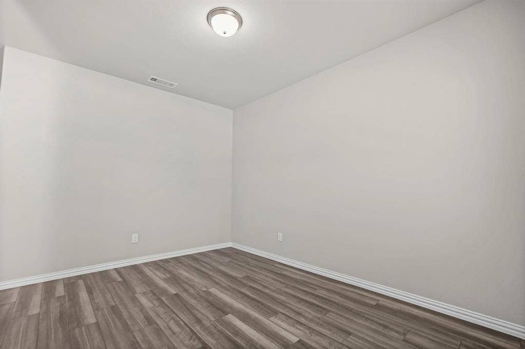 Neutral wall finishes, wood-finish flooring, and a flush-mount ceiling light