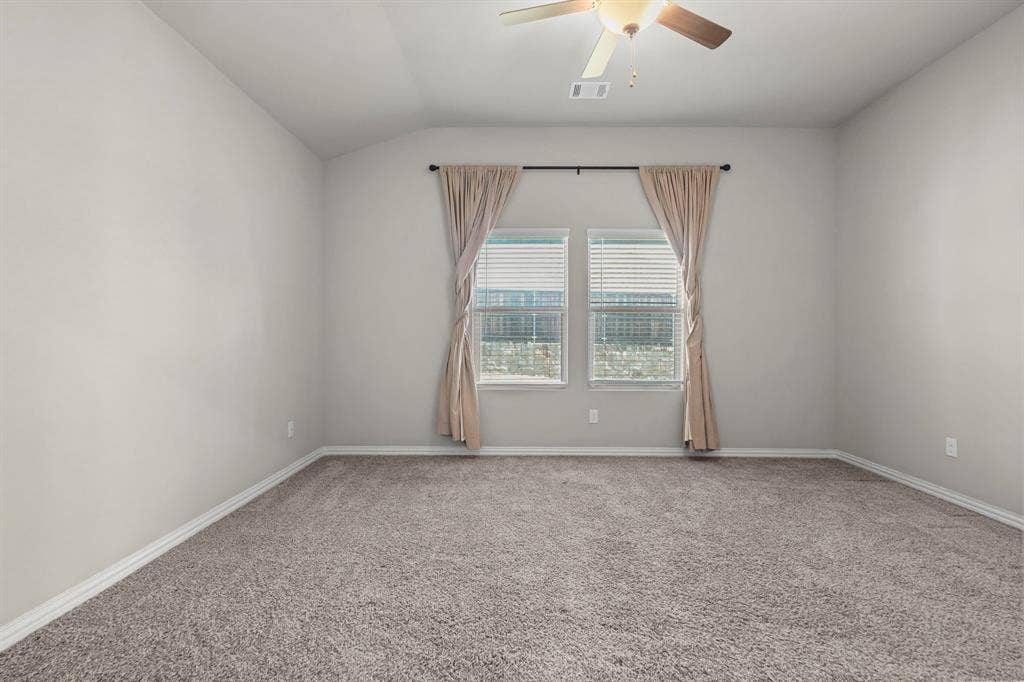 Recessed ceiling with a central ceiling fan, two windows with blinds, and neutral carpeting