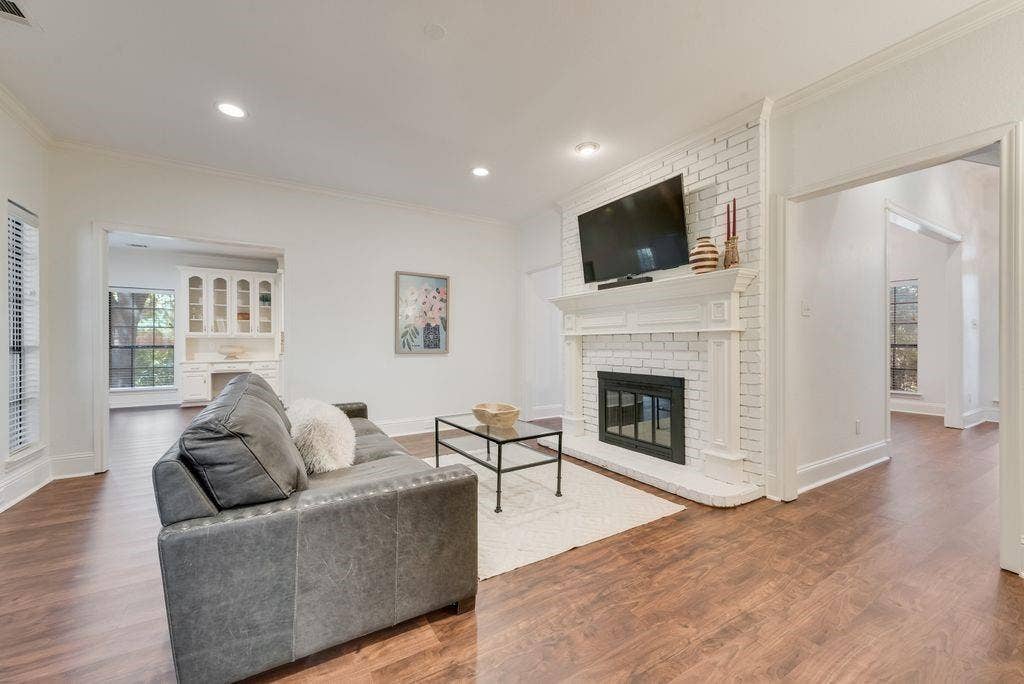 Second living area with wall of windows, brick pass through fireplace and mantle.