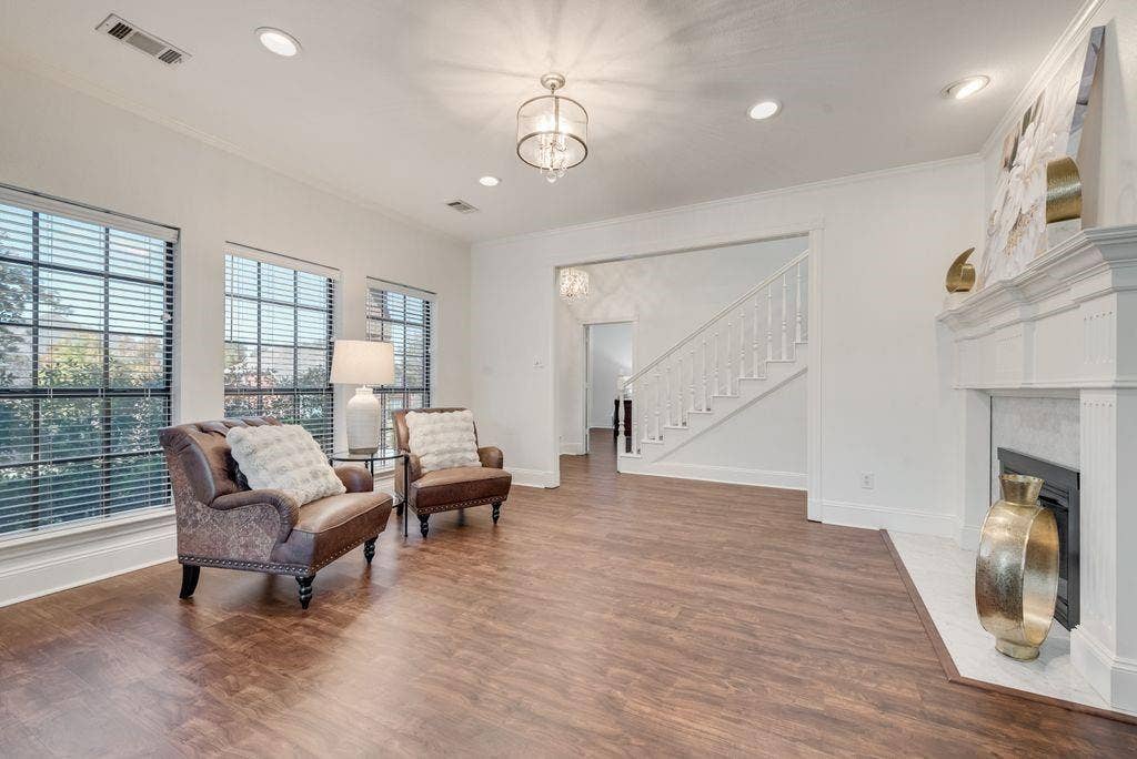Living space with beautiful mantle and staircase.
