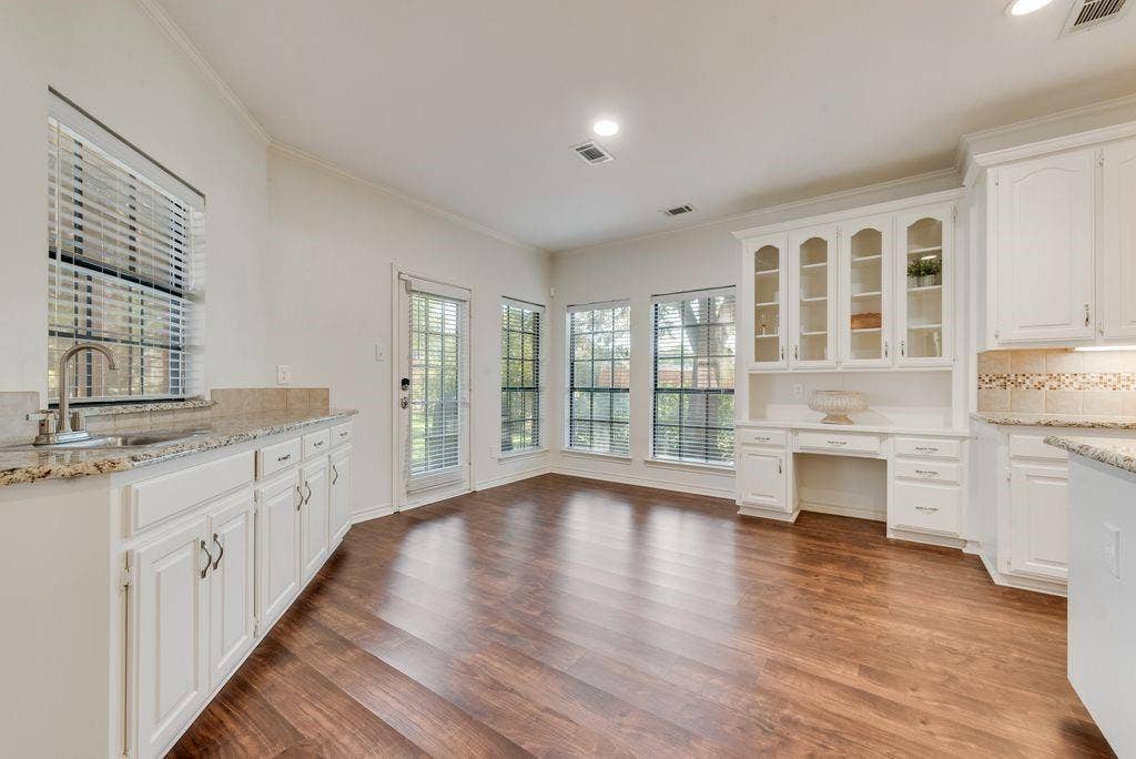 spacious breakfast area with built in hutch, desk and buffet, opens to patio with pergola.