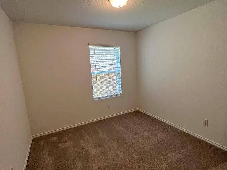 610 Grenada Lake Drive, Princeton, TX 75407 Neutral wall finishes with a single window featuring horizontal blinds