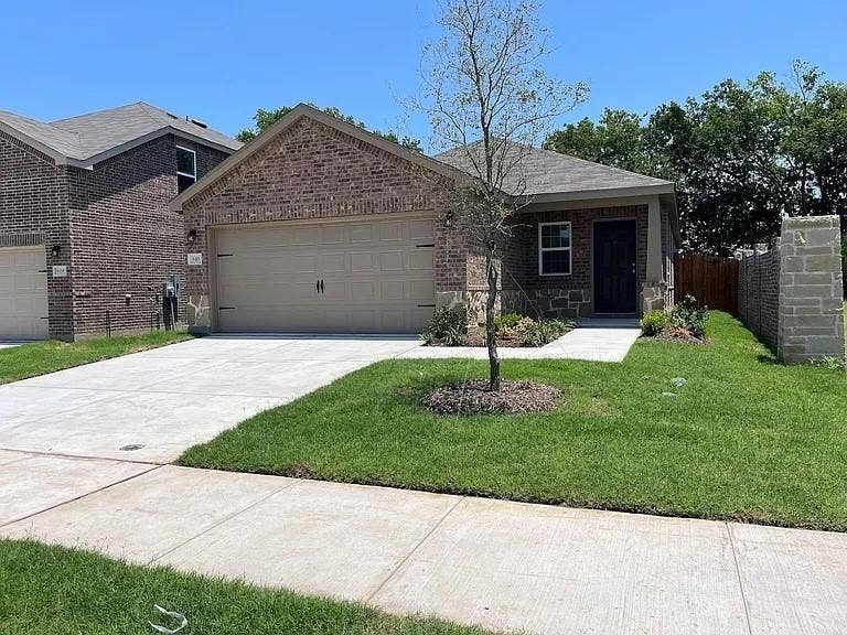610 Grenada Lake Drive, Princeton, TX 75407 Brick and stone facade, covered front entry, attached garage, concrete driveway, and established landscaping