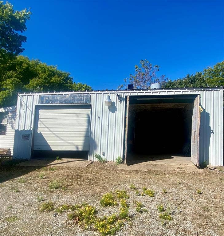Front of garage with double doors on Main Street.  Open door is paint booth.