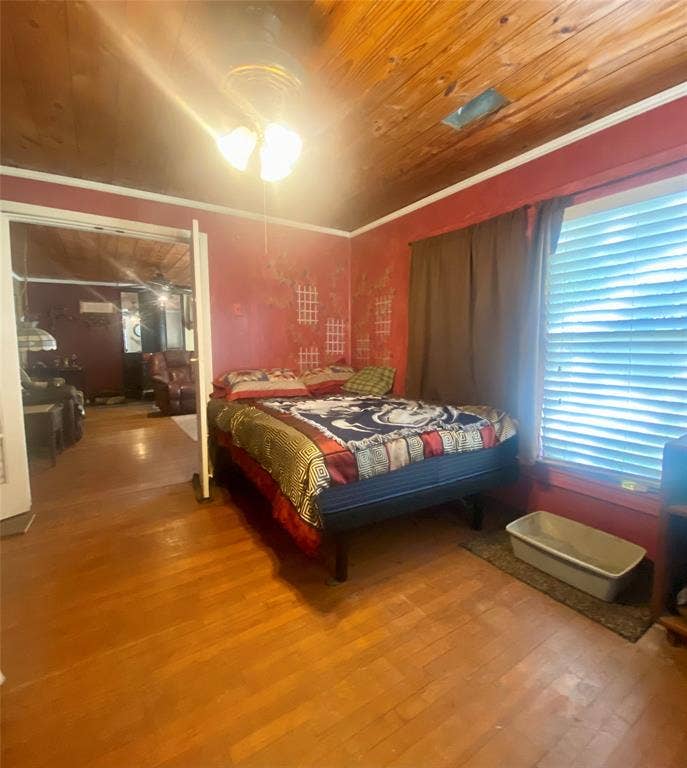 Wood-finish flooring with a wood plank ceiling and a ceiling fan light fixture