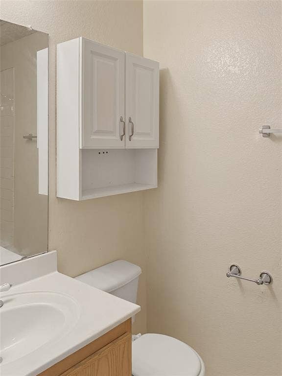 Wood-finish vanity with an integrated white sink and mirror
