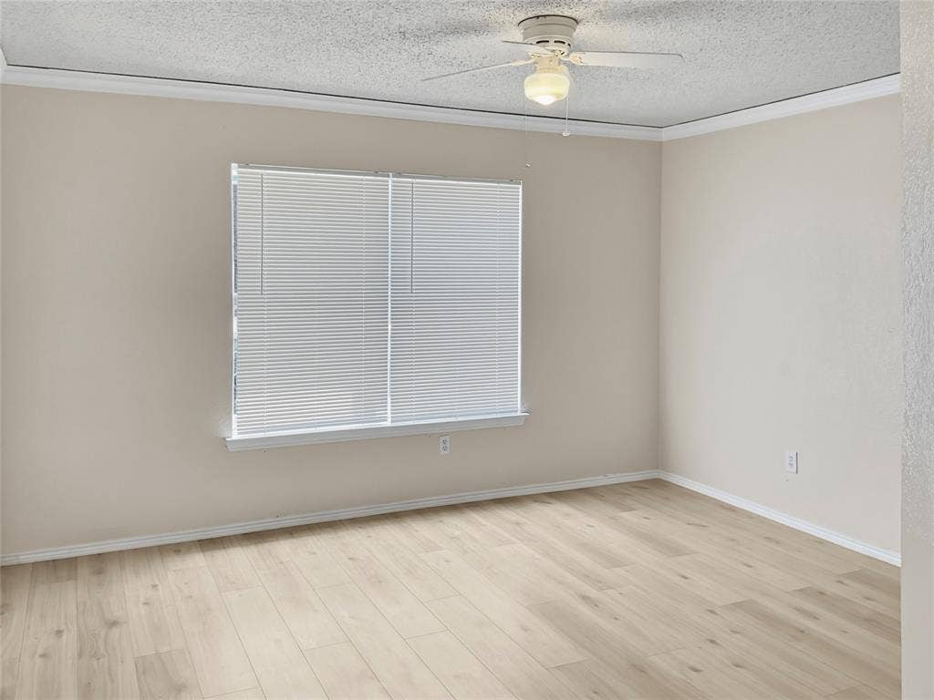 Bright and spacious bedroom featuring pristine wood-finish flooring, neutral wall finishes, horizontal blinds at the window, and a ceiling-mounted fan with integrated lighting fixture