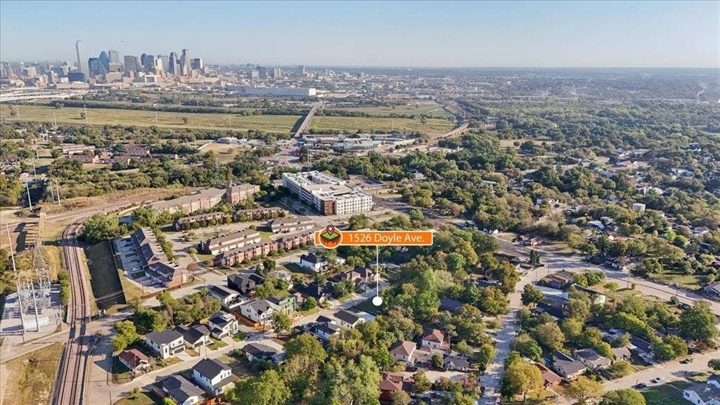 Aerial perspective showcasing a residential area with varied housing styles, mature trees, and urban infrastructure