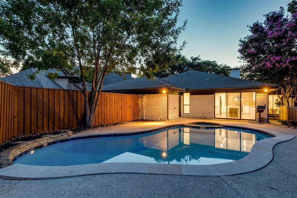 7001 Rocky Top Circle, Dallas, TX 75252 Pool at dusk featuring a patio area and an in ground hot tub