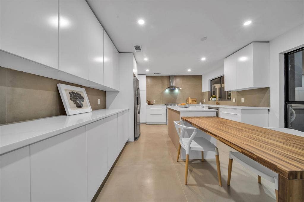 7001 Rocky Top Circle, Dallas, TX 75252 Kitchen with white cabinets, wall chimney exhaust hood, appliances with stainless steel finishes, and tasteful backsplash