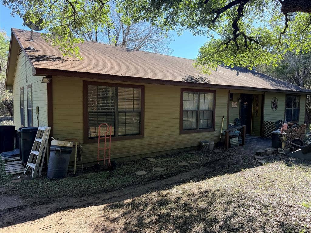 177 Highline Road, Valley Mills, TX 76689 Charming single-story home featuring horizontal siding exterior, multiple large windows with dark frames, and a covered front porch