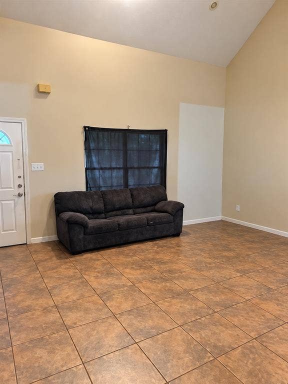 1017 W 3rd Street, Taylor, TX 76574 Open-concept living space highlighting high ceilings, clean tile flooring, and cozy seating layouts.
