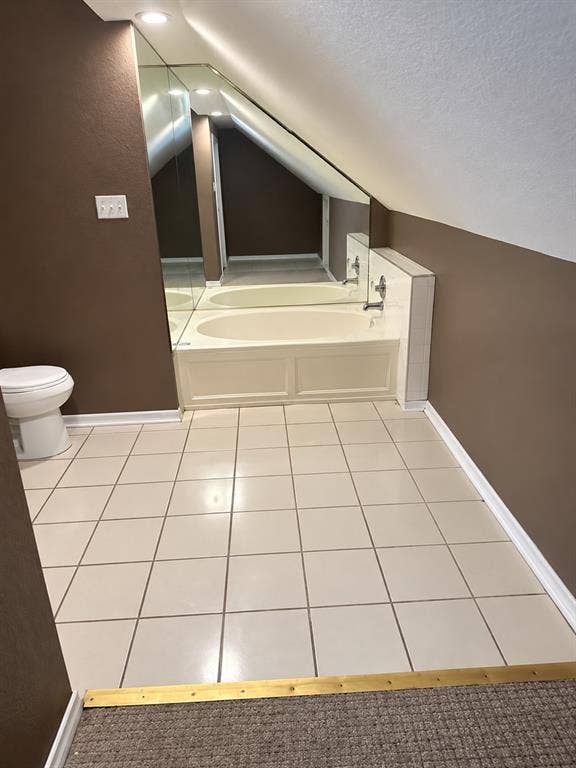 1017 W 3rd Street, Taylor, TX 76574 Alternate perspective of the primary bath's deep soaking tub and tiled surround.