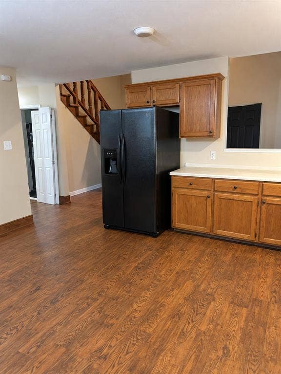 1017 W 3rd Street, Taylor, TX 76574 Bright kitchen featuring warm wood cabinetry, modern black appliances, and durable tile flooring.