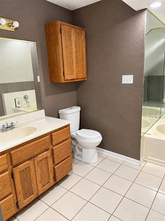 1017 W 3rd Street, Taylor, TX 76574 Full bathroom complete with a expansive wood vanity, large mirror, toilet, and overhead storage cabinet.