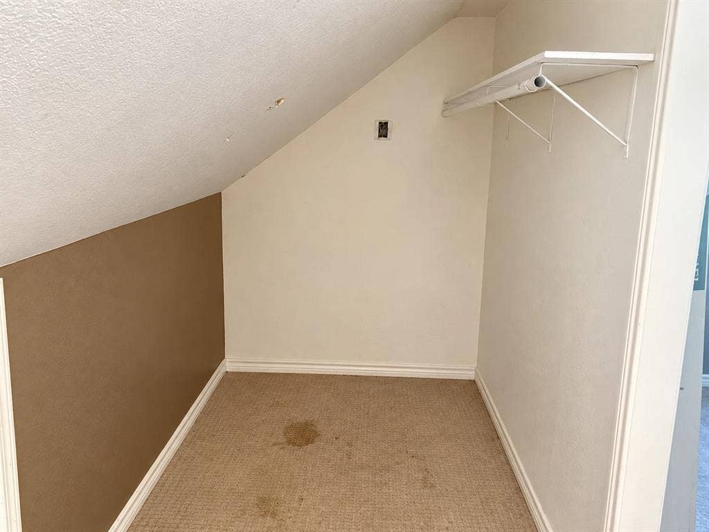 1017 W 3rd Street, Taylor, TX 76574 Deep walk-in closet space featuring built-in hanging rods and organized shelving.