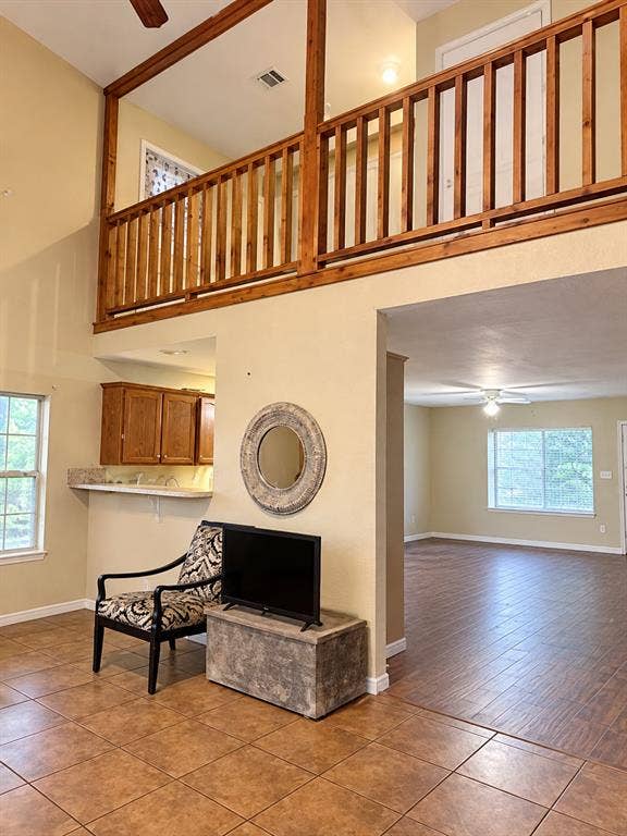 1017 W 3rd Street, Taylor, TX 76574 Alternate angle of the living room showing the staircase railing and second-story balcony overlook.